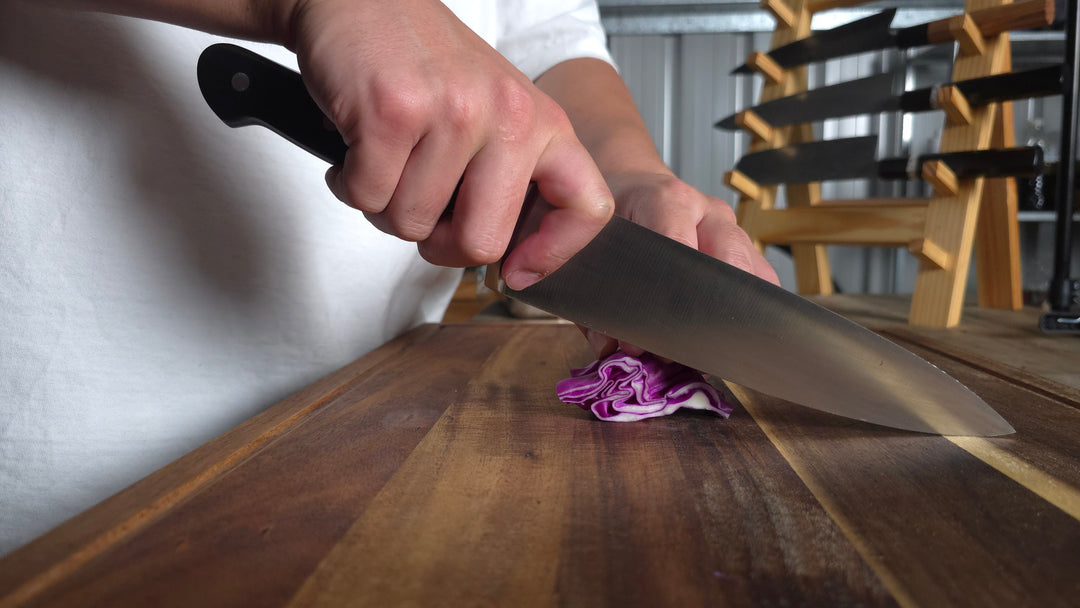 Chef slicing pepper with curved knife.